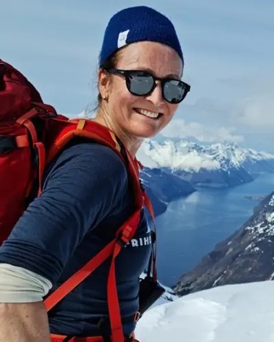En mann med hatt og solbriller på et snødekt fjell