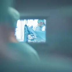 Bilde av helsepersonell som ser inn gjennom vinduet på en operasjonsstue.