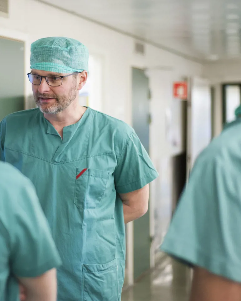 Bilde av viseadministrerende direktør og ortoped Tor Kjetil Nerhus som står i grønt tøy inne i en operasjonskorridor